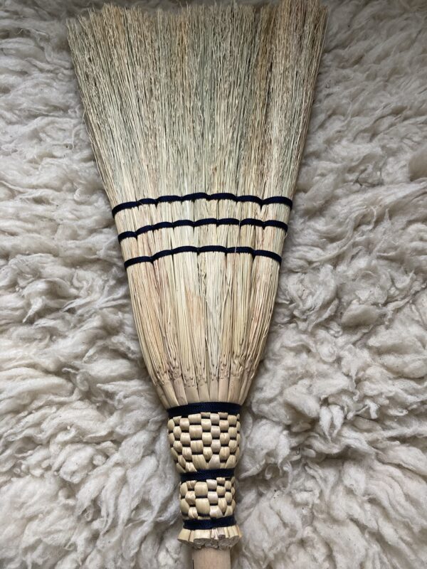 Full size homemade broom braided with black thread on a wooden ash handle.